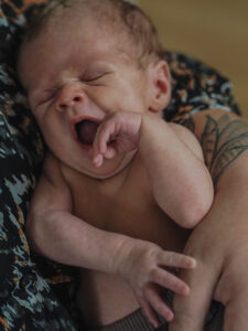 Familienfotografie Herten - gähnendes Neugeborenes auf Mamas Arm