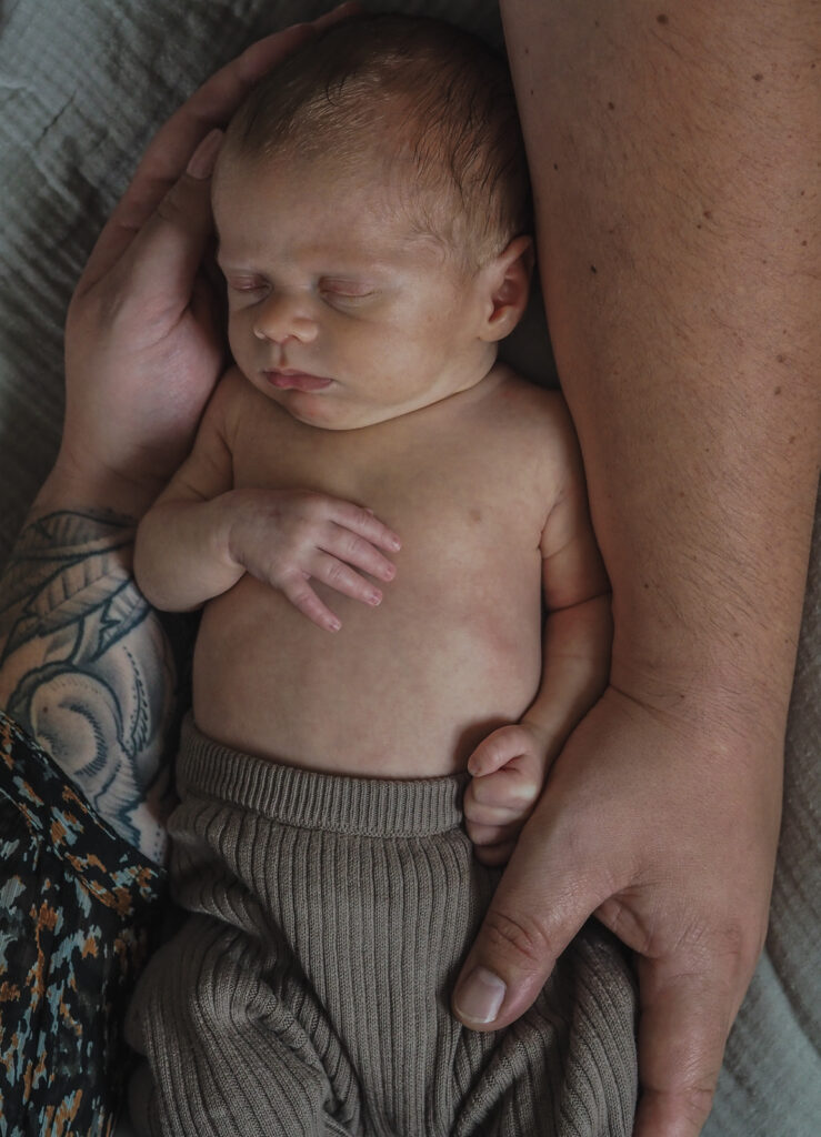 Familienfotografie Herten - Neugeborenes zwischen den Armen von Mama und Papa