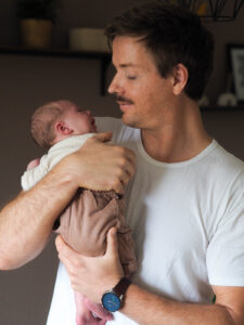 Vater hält seine neugeborene Tochter im Arm