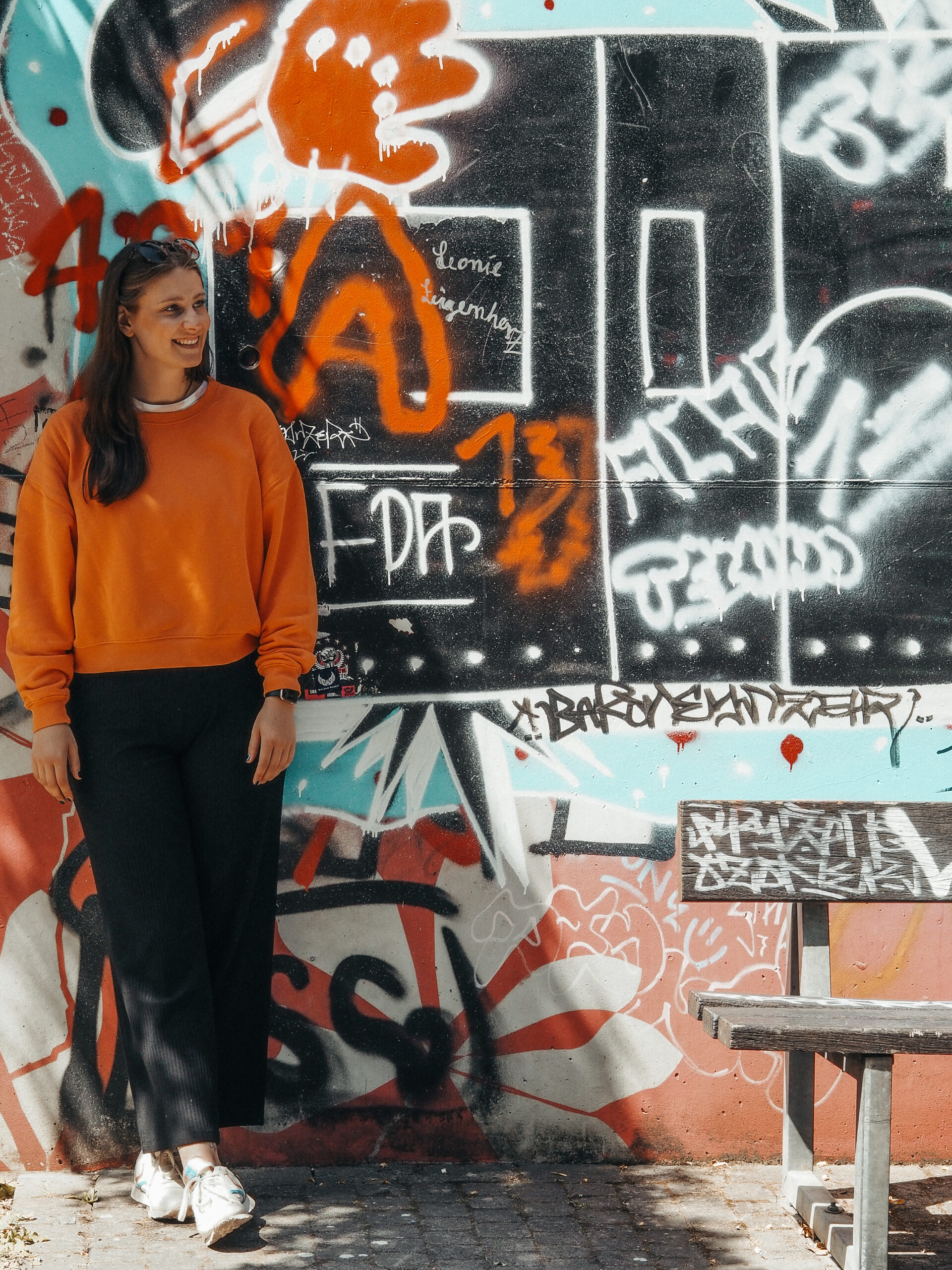 Junge Frau vor einer Graffitiwand