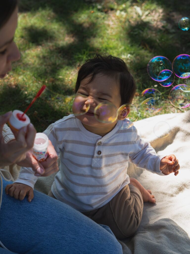 Kind lacht inmitten von Seifenblasen