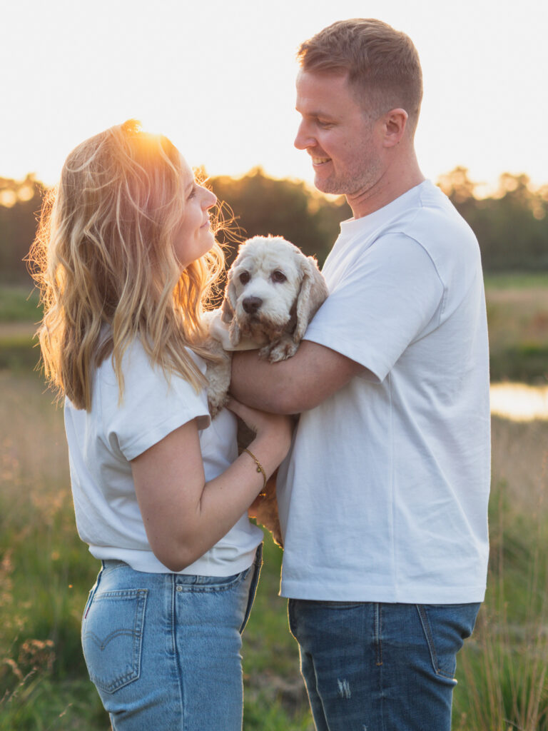 Pärchen hält gemeinsam Hund auf dem Arm