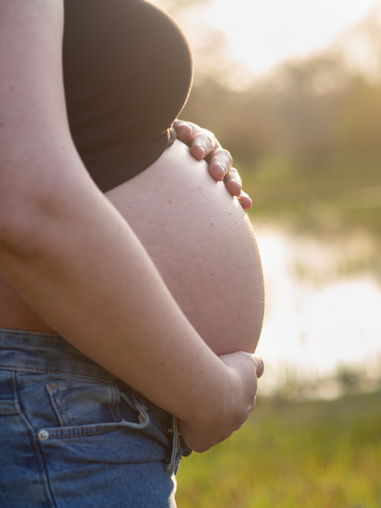 nackter Babybauch im Sonnenuntergang