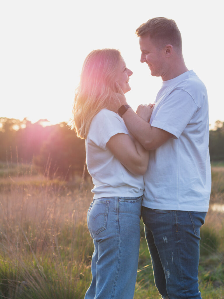 Mann hält Gesicht seiner Frau und strahlt sie an